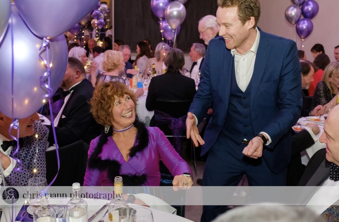 Richard Kettle performing close-up magic for a guest at a charity ball