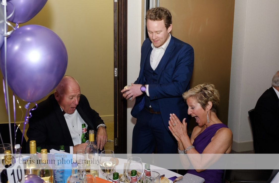 A ball guest gasping as a trick is revealed at her table