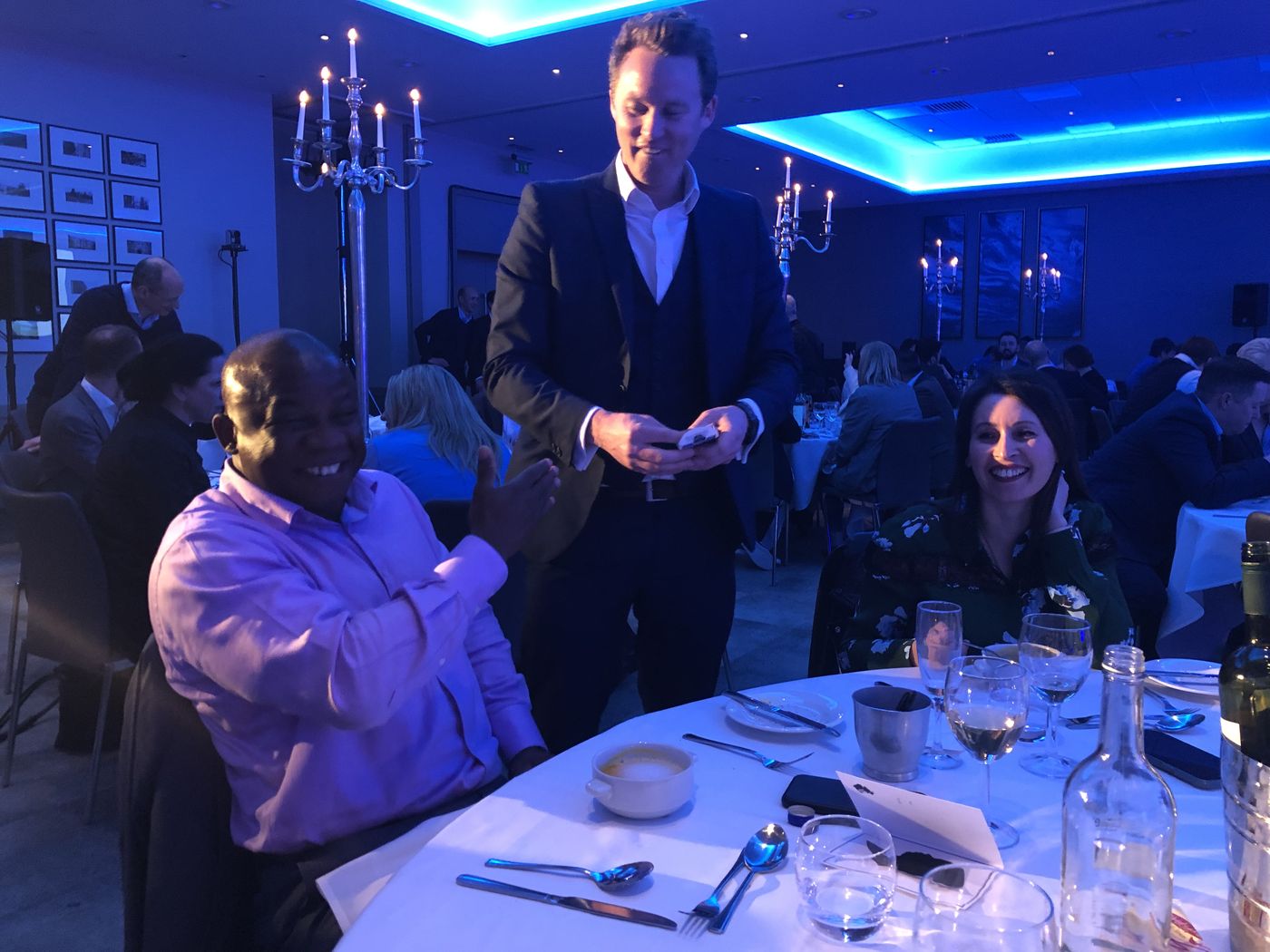 Richard Kettle performing at a table during a corporate dinner