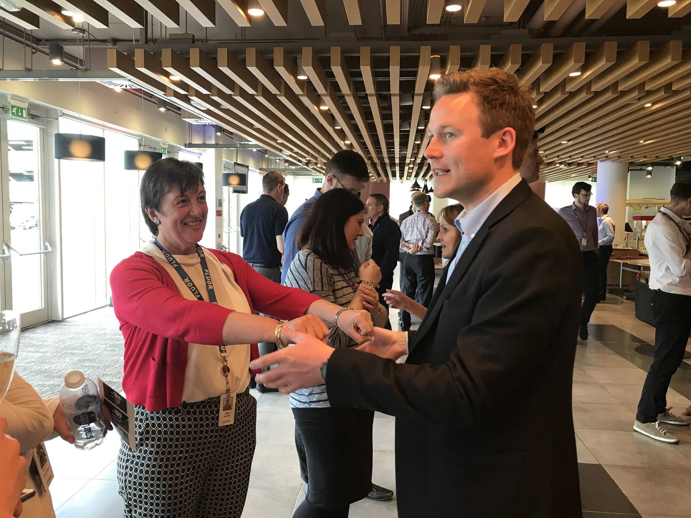 A delegate with a lanyard taking part in a card trick at a corporate event