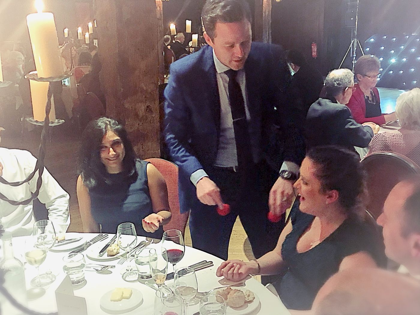 Richard Kettle performing a sponge ball routine for guests at a candlelit dinner