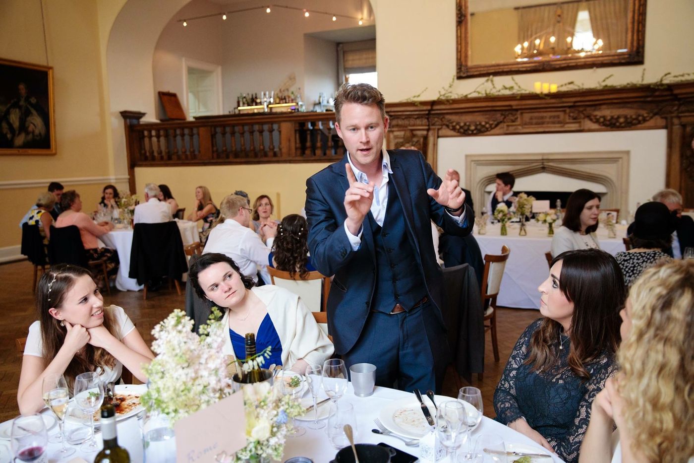 Guests at a celebration watching Richard Kettle reveal a card in a panelled function room