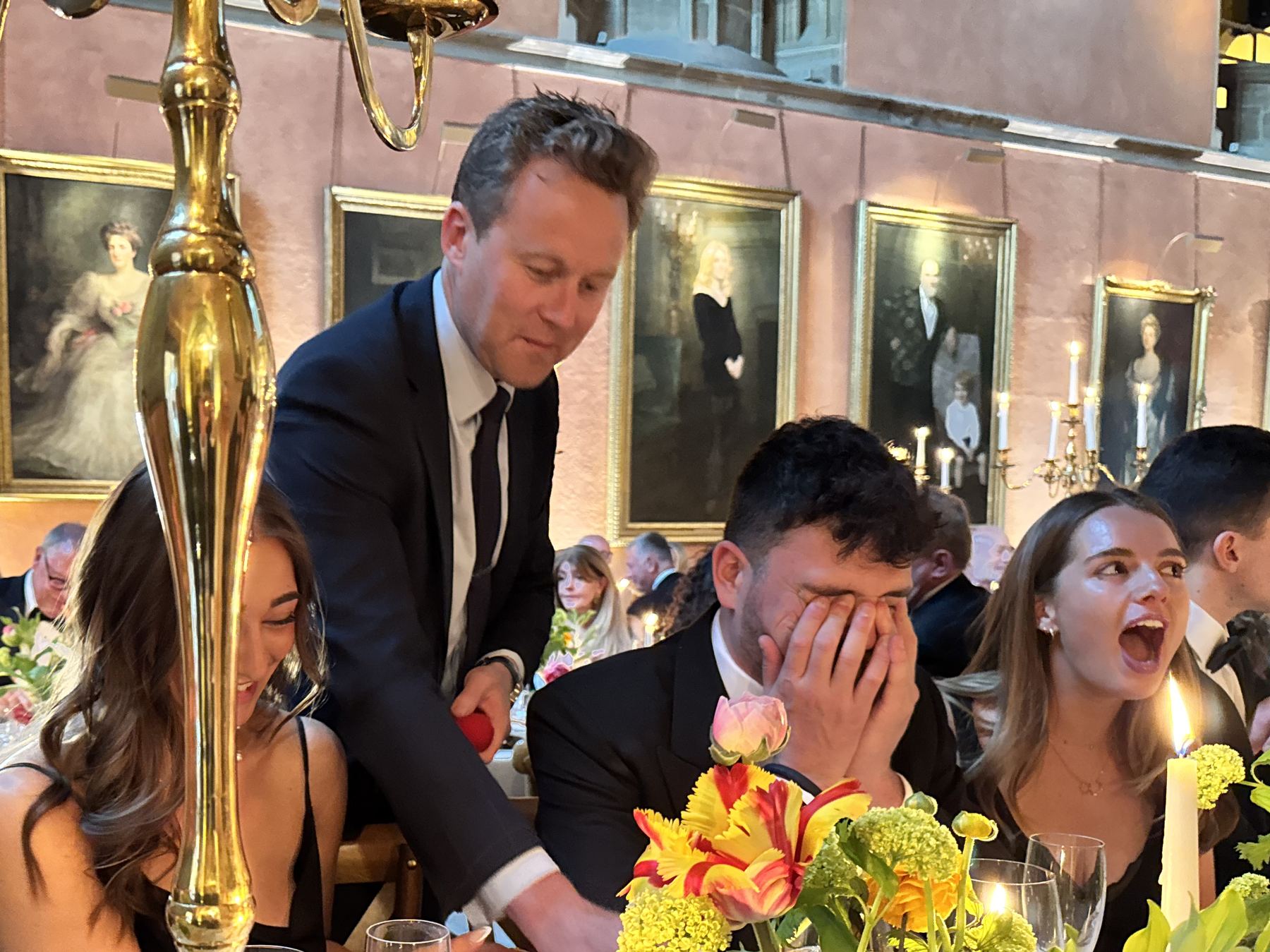 Guests at a black-tie party reacting with astonishment to close-up magic