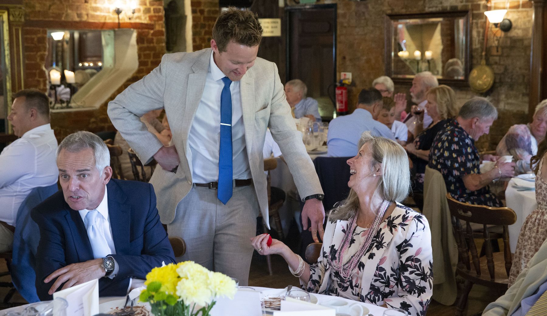 A party guest laughing in delight as a sponge ball appears in her hand during close-up magic