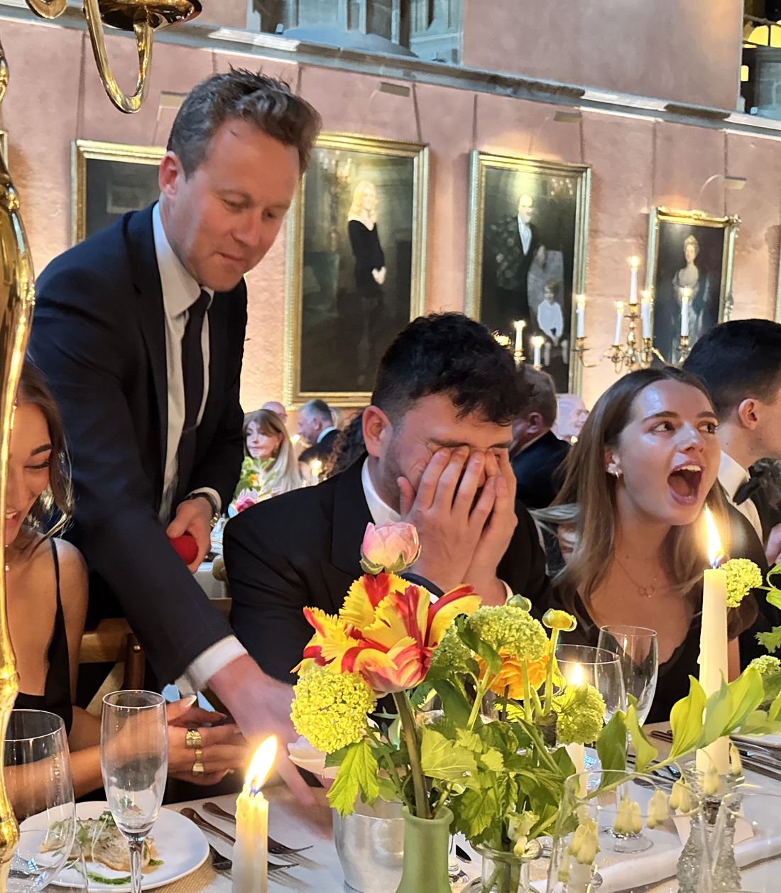 Guests at a black-tie dinner reacting with disbelief to close-up magic