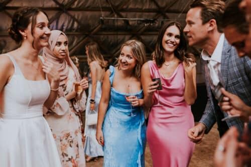 Bridesmaids laughing in astonishment during close-up magic
