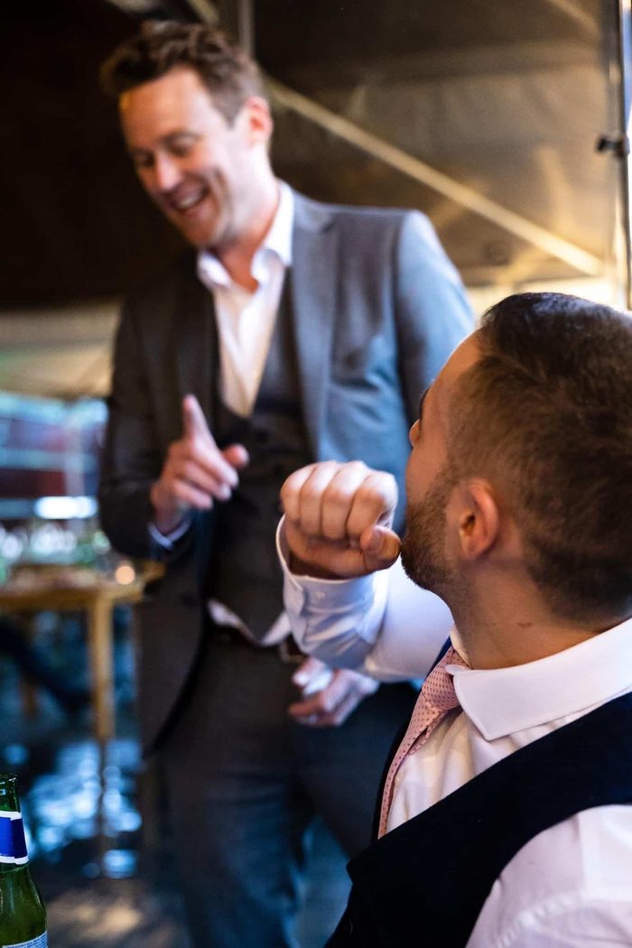 Guests laughing together during close-up magic