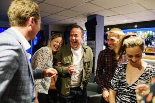 A group of friends laughing together during close-up magic