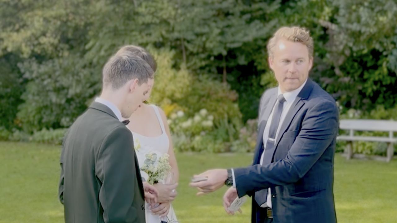 Richard Kettle performing close-up magic for a bride and groom in a garden