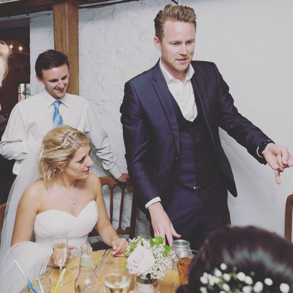 A bride laughing at the top table as Richard Kettle performs
