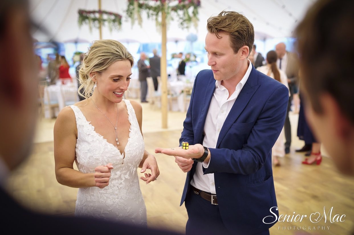 A bride watching a Rubik's cube appear in her own hand during close-up wedding magic