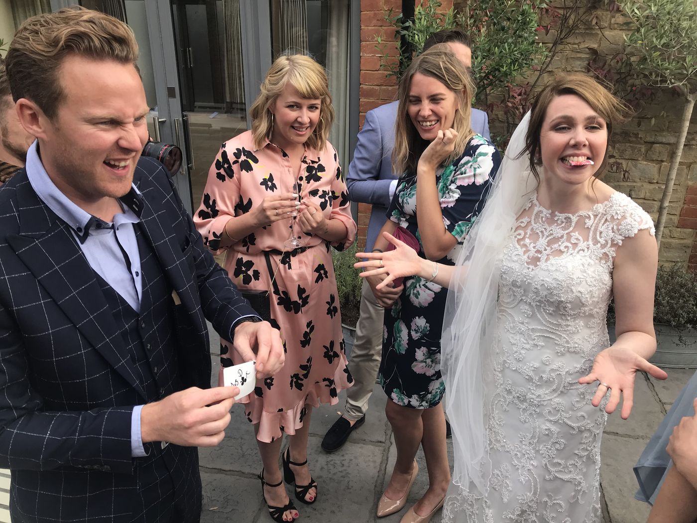 A bride and her guests reacting to close-up magic with Richard Kettle during a drinks reception