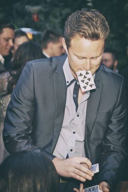 Richard Kettle performing a card trick at an outdoor wedding