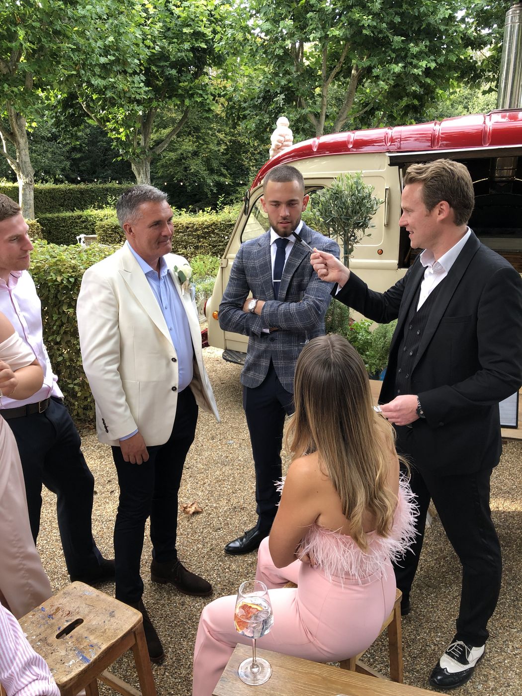 Richard Kettle performing close-up magic for wedding guests in a garden