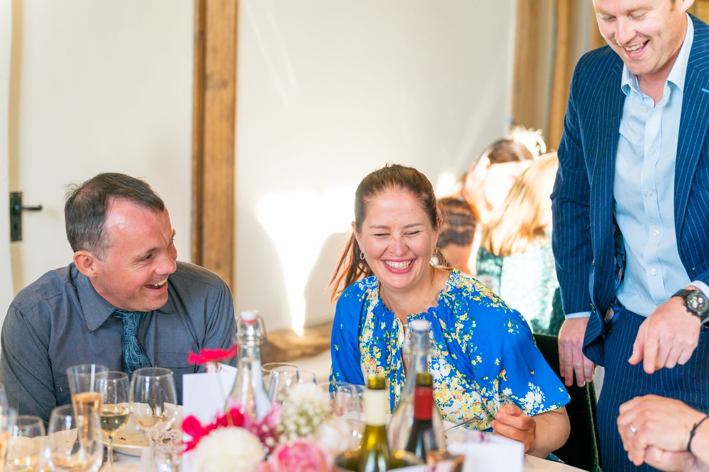 A wedding guest laughing at her table during close-up magic