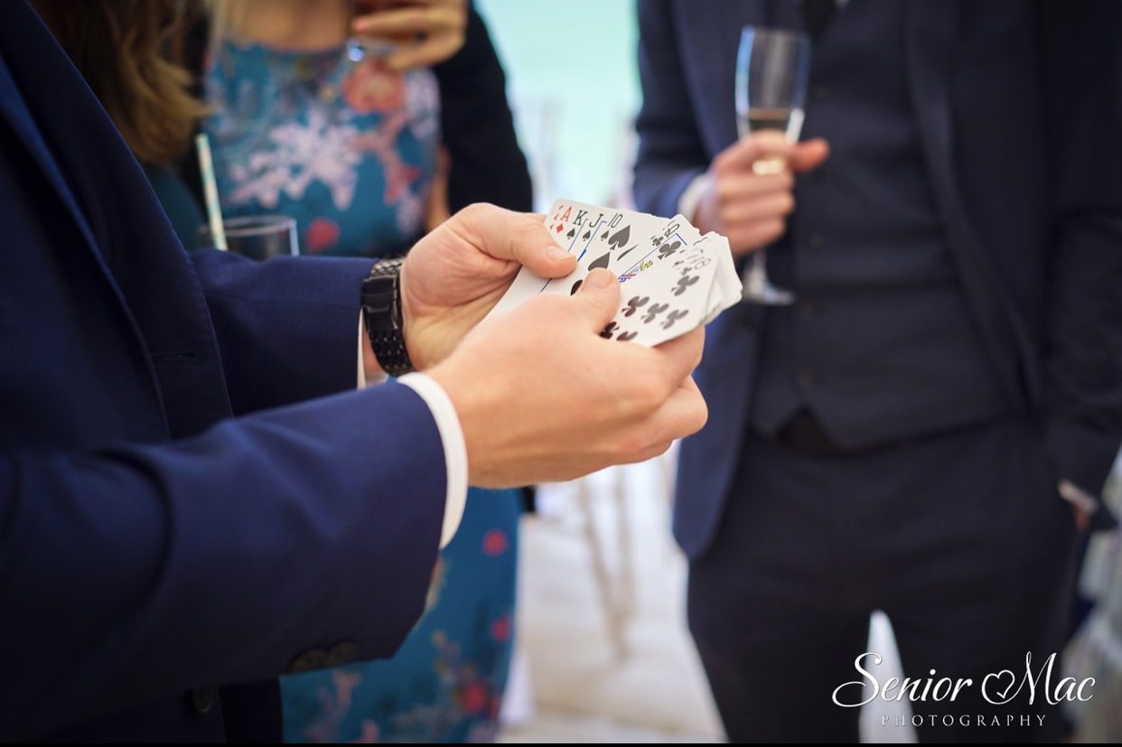 A fan of playing cards held out to guests during wedding magic