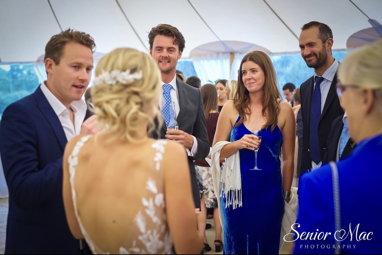 Wedding guests in a marquee watching close-up magic with the bride